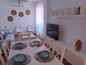 - un salon avec une table, des chaises et une télévision dans l'établissement Casa, 300 metros Playa, Wifi, Parking., à Vera