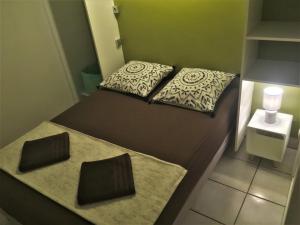 Habitación pequeña con 1 cama con 2 almohadas en Baz créole, en Deshaies