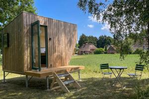 a small wooden cabin with a picnic table and two chairs at Sleep Space 01 - Green Tiny Spot Geltinger Bucht in Steinbergkirche