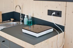 a kitchen counter with a laptop on top of it at Sleep Space 01 - Green Tiny Spot Geltinger Bucht in Steinbergkirche