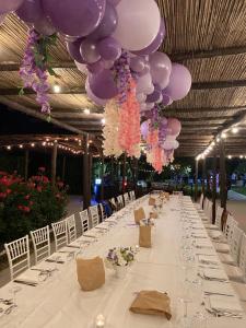 a long long table with purple and pink balloons at B&B Terre di Paestum in Capaccio-Paestum
