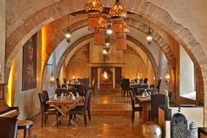 a restaurant with tables and chairs and a fireplace at Dar L'Oussia in Essaouira