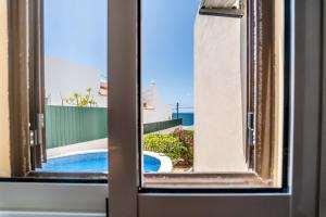 Blick auf den Pool durch ein Fenster in der Unterkunft Villa Oceano by Indigo in Carvoeiro