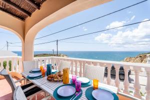 a table on a balcony with a view of the ocean at Villa Oceano by Indigo in Carvoeiro
