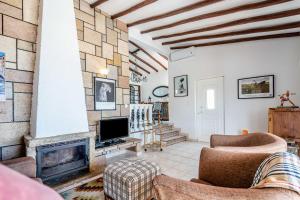 a living room with a fireplace and a tv at Villa Oceano by Indigo in Carvoeiro