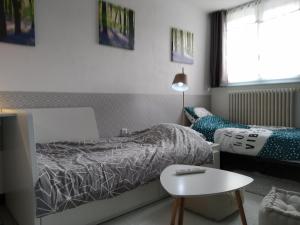 Un dormitorio con una cama, una mesa y una silla. en Gîte familial, en Plouguenast Langast 40 fotos más