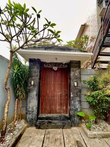 una puerta de madera en el lateral de un edificio en Satran Villa @ Kuta Bali, en Legian