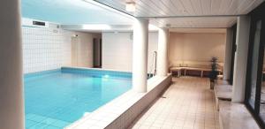 a large swimming pool in a building with at Fewo am Meer, mit Schwimmbad und Sauna in Timmendorfer Strand
