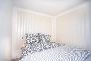 1 dormitorio con 1 cama con manta azul y blanca en Fewo Sommerliebe, mit Meerblick und Schwimmbad direkt am Hansapark en Sierksdorf