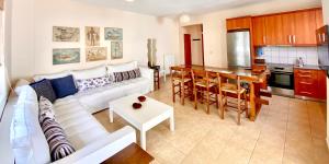 a living room with a white couch and a kitchen at Atreas’ Art Studio in Chania Town