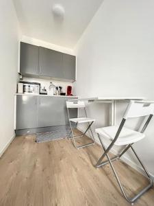 une cuisine avec deux chaises, une table et un comptoir dans l'établissement Station 173 D Bruxelles-charleroi-airport, à Charleroi