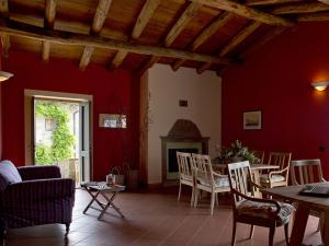 uma sala de estar com paredes vermelhas e uma mesa e cadeiras em Costa D'Orsola em Pontremoli