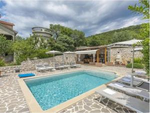 a pool in a yard with chairs and a building at Villa Tomko in Brovinje