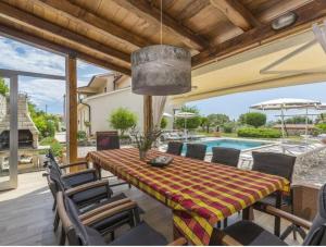 a patio with a table and chairs and a pool at Villa Tomko in Brovinje
