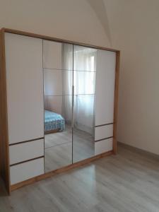 um armário com portas de vidro num quarto com uma cama em Casa vicino al mare em Piombino