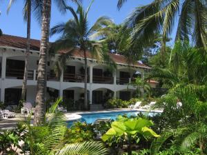 un complejo con piscina y palmeras en Hotel Pochote Grande, en Jacó