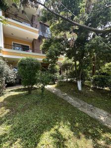 a yard in front of a building with trees at Dreamland Oasis 1st floor Apartment With a Garden by the Sea in Chakvi