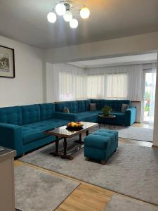 ein Wohnzimmer mit einem blauen Sofa und einem Tisch in der Unterkunft Apartment 528 in Sarajevo
