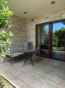 un patio con mesa y sofá en Dreamland Oasis 1st floor Apartment With a Garden by the Sea, en Chakvi