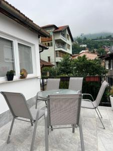 eine Terrasse mit einem Tisch und Stühlen auf dem Balkon in der Unterkunft Apartment 528 in Sarajevo