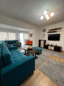ein Wohnzimmer mit einem blauen Sofa und einem TV in der Unterkunft Apartment 528 in Sarajevo