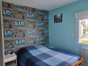 - une chambre avec un lit et un mur avec le signe sigma dans l'établissement Le Haut du Theux - Gîte de vacances, à Charleville-Mézières