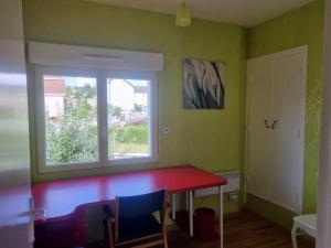 une salle à manger avec une table rouge et une fenêtre dans l'établissement Le Haut du Theux - Gîte de vacances, à Charleville-Mézières