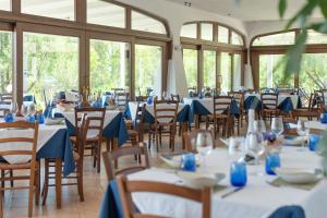 una habitación con mesas y sillas con manteles azules en Hotel Biderrosa, en Cala Liberotto