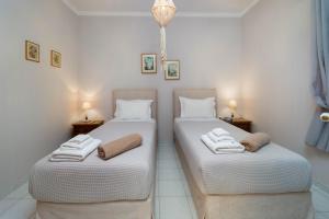 two beds in a room with towels on them at Marilu's, Paxos Port House in Gaios