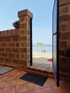 een deur naar het strand vanuit een huis met uitzicht bij La Casa sulla Spiaggia in Marzamemi