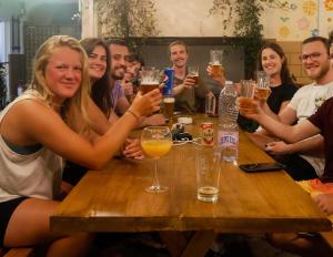 a group of people sitting around a table drinking beer at The Galley Party Hostel in Shkodër