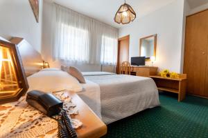 ein Hotelzimmer mit einem Bett mit Telefon darauf in der Unterkunft Hotel Ristorante Sagittario in Feltre