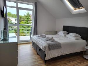 a bedroom with a bed and a large window at Pokoje Gościnne Akwatel in Jastarnia