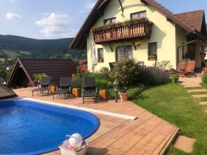 a house with a swimming pool in front of a house at Apartmany Samuel in Rokytnice nad Jizerou