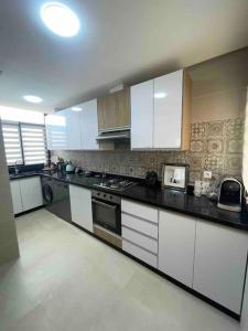 uma cozinha com armários brancos e um forno com placa de fogão em Appartement Haut standing Colina smir Kabila em Sania Torres