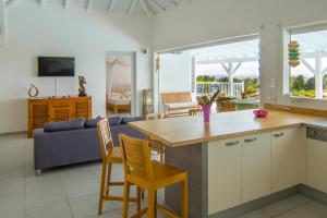 a kitchen and living room with a table and chairs at Villa La Favorite in Capesterre-de-Marie-Galante