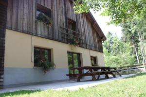 a building with a picnic table in front of it at Gîte l'essentiel in Arc-sous-Cicon