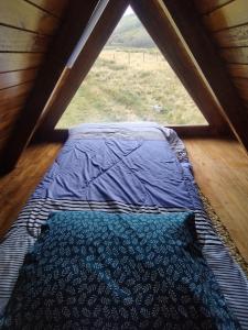 a bed in a room with a large window at Chimborazo Basecamp in Chimborazo