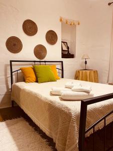 ein Schlafzimmer mit einem Bett mit gelben und grünen Kissen in der Unterkunft Casa DAlva in Vila Alva + 17 Fotos