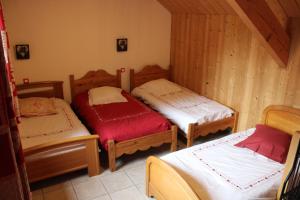 a room with three beds in a cabin at Gîte l'essentiel in Arc-sous-Cicon