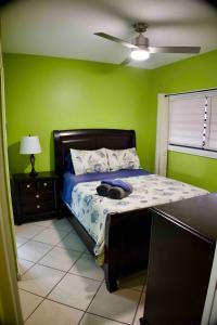 a bedroom with a bed with green walls at Relaxing 1bed 1bath Villa In Downtown Red Hook! in St Thomas
