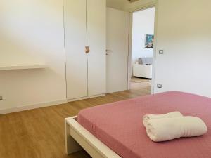 a white bedroom with a bed and a cabinet at Le Conchiglie Residence in Porto Torres