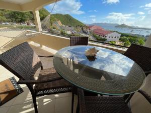 a glass table and chairs on a balcony with a view of the ocean at Amazing View 1 Bed1 Bath Villa On Red Hook Strip in St Thomas