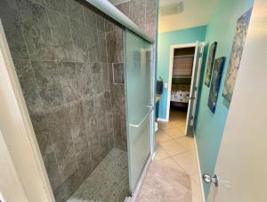 Nazareth的住宿－Amazing View 1 Bed1 Bath Villa On Red Hook Strip，浴室里设有玻璃门淋浴