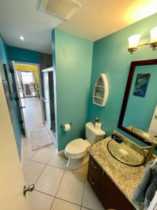 a bathroom with a toilet and a sink and a mirror at Amazing View 1 Bed1 Bath Villa On Red Hook Strip in Nazareth