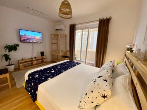 - une chambre avec un lit et une télévision murale dans l'établissement Lucas Central Oasis Studios, à Tirana