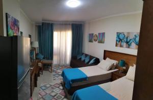 Habitación de hotel con 2 camas y sofá en Aqua View north coast for Egyptians only, en El Alamein