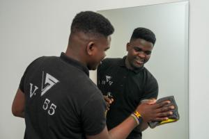 twee mannen staan naast elkaar en kijken naar een tablet bij Villa 55 in Zes oktober (stad)