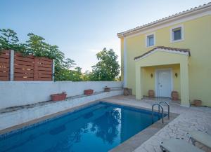 a house with a swimming pool and a fence at Villa Olive by Seaside in Tsilivi