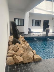 a swimming pool with a rock wall in a house at Appartement 1 Riad Dar Samar in Tamraght Ouzdar